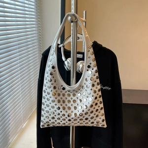 White hobo shoulder bag with silver metal rivets on a display stand in street style