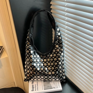 Chic black rivet underarm bag with silver studs and glossy finish in artistic shadow setting