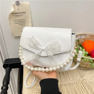 White faux leather crossbody bag with large mesh bow and decorative pearl handle
