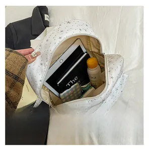 Interior view of white canvas backpack with star pattern showing tablet and daily items