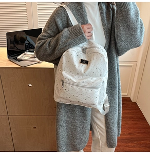 Fashionable white backpack with grey stars shown in a cozy home office setting