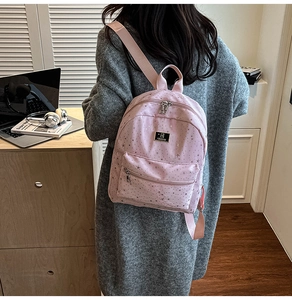 Detail shot of the pink backpack featuring silver star patterns and JIUHAI brand logo