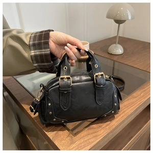 Detailed top view of black lychee grain handbag with gold hardware and top zipper closure