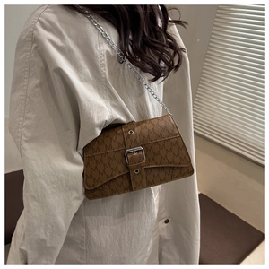 Detail of coffee brown crossbody bag with M-letter monogram and silver chain strap