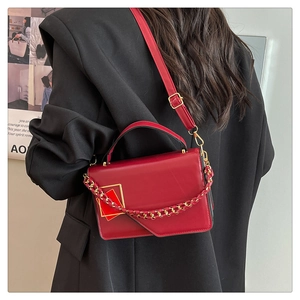 Borsa a tracolla in pelle rossa con catena e patta, vista posteriore indossata da modella