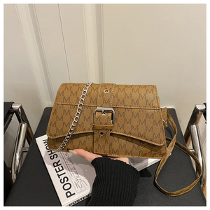 Detail of vintage brown crossbody bag featuring M-pattern print and silver buckle
