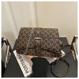 Detail of vintage brown M-patterned crossbody bag with silver chain and buckle