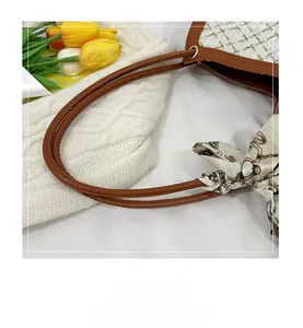 Détail du sac en tweed avec bordure en cuir marron et ruban en soie sur fond en tricot