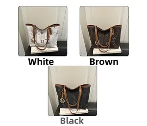 Three large printed tote bags in white, brown, and black with metal M charms