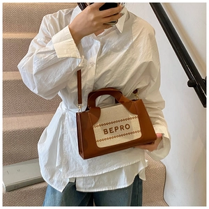 Vue détaillée des coutures contrastées et du logo BEPRO sur ce petit sac carré élégant