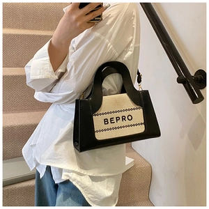 Détail du sac cabas en toile et cuir bicolore avec inscription BEPRO en noir