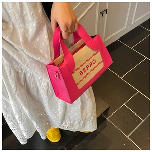 Détail d'un sac en cuir rose vif avec panneau en toile beige et broderie BEPRO