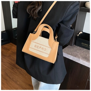 Sac à bandoulière en toile et cuir avec broderie BEPRO porté par un mannequin