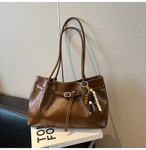 Dettaglio della borsa tote vintage marrone scuro con fibbia in metallo e perline