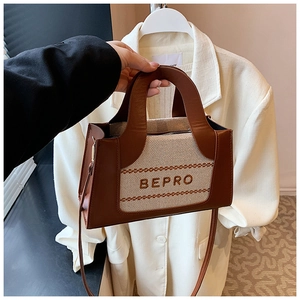 Détail du sac carré vintage avec lettrage BEPRO sur toile et bandoulière en cuir brun