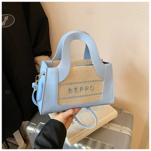 Détail du sac en cuir PU bleu clair avec tissu tissé beige et broderie lettrée BEPRO
