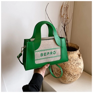 Détail du sac à main en cuir vert et toile beige avec broderie BEPRO élégante