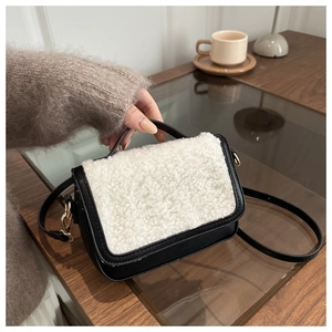 Detail of vintage saddle bag featuring black leather and white shearling patchwork