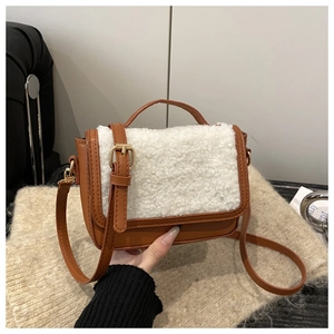 Detail of vintage saddle bag featuring brown leather and white faux shearling texture