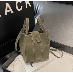 Detail of olive green suede bucket bag featuring contrast stitching and gold logo
