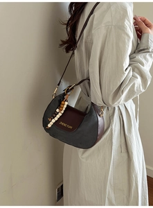 Dettaglio di una borsa hobo retrò in pelle scamosciata grigia con patta marrone
