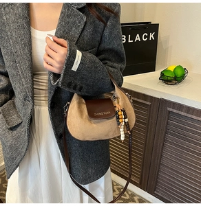 Dettaglio della borsa a spalla a mezzaluna con patchwork in pelle scamosciata e perline