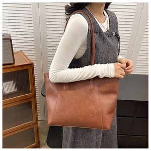 Vintage caramel brown tote bag in soft faux leather shown in a lifestyle indoor setting