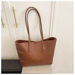 Detailed view of deep brown vintage leather tote bag showing texture and long straps