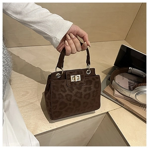 Close-up of leopard print handbag featuring a gold twist lock and frosted texture