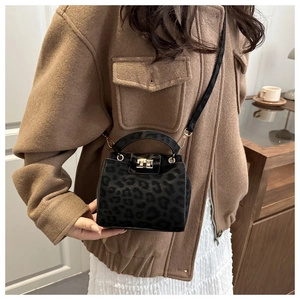 Detail of a mini leopard print handbag with a gold twist lock and elegant top handle