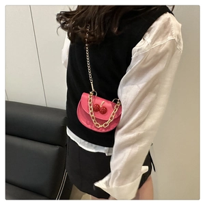 Pink mini crossbody bag featuring 3D cherry accents and a gold chunky chain strap detail