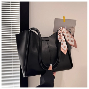 Detail of black PU leather tote bag with elegant pink polka dot silk scarf handle decor