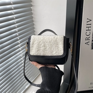 Vintage style lamb wool saddle bag for women featuring black leather and gold hardware