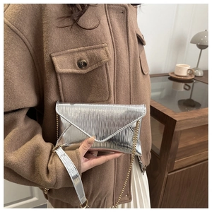 Chic silver envelope clutch bag with crinkled metallic texture and gold chain strap