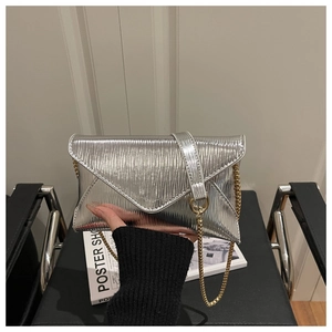 Close-up of silver envelope bag with vertical pleated texture and golden metal chain
