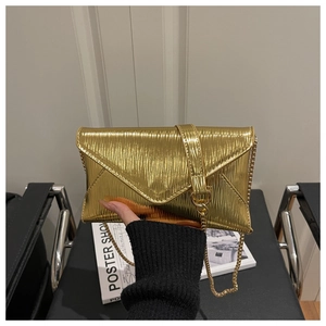 Detail of gold envelope bag showing pleated metallic texture and V-shape flap with chain