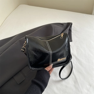 Black oil wax leather shoulder bag with white contrast stitching and gold hardware details
