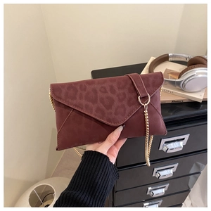 Dettaglio pochette a busta leopardata bordeaux con tracolla a catena dorata