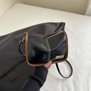 Minimalist black and brown large tote bag with white stitching and gold metal logo