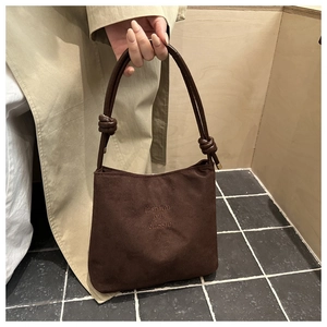 Détail du sac seau en velours côtelé marron foncé avec broderie et poignée nouée