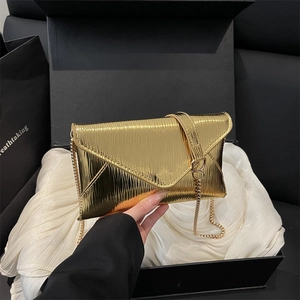 Golden envelope evening bag with pleated texture and delicate metal chain strap