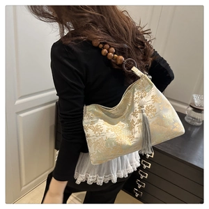 Detail of landscape brocade shoulder bag with wooden bead strap and tassel charm