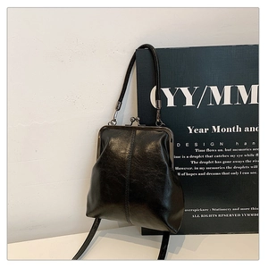 Detail of vintage black leather doctor bag with silver metal clasp and fine shoulder strap