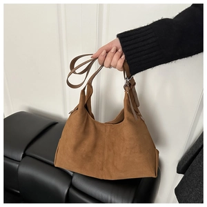 Detailed close-up of the side seam and brown suede texture on the large hobo bag