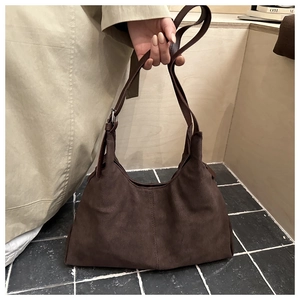 Detail view of deep brown suede tote showing fine stitching and matte texture