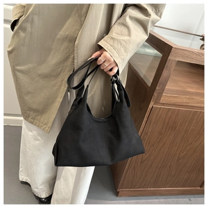 Macro shot of minimalist black suede tote bag with soft texture and sturdy shoulder strap