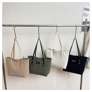 Detail of corduroy tote bags in multiple colors hanging on a display rack