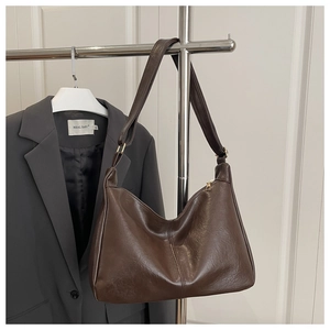 Detail der braunen Hobo-Tasche auf grauem Blazer für einen modernen City-Look