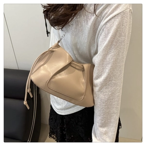 Detail of beige pleated shoulder bag with silver chain strap and drawstring design