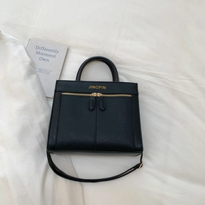 Vue détaillée du sac à main noir texturé avec fermetures éclair dorées chic